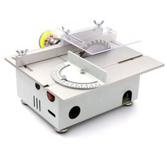 a machine that is sitting on top of a white surface with a yellow disc in the middle