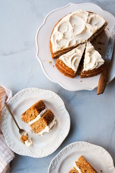 two plates with slices of carrot cake on them and one slice has been cut from it