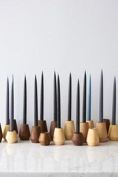 a row of wooden candles sitting on top of a white counter next to each other