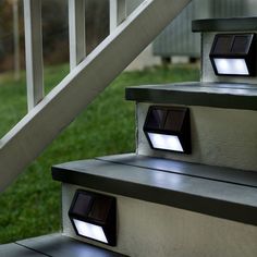 some stairs with lights on them and grass in the background