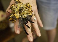 a person's hand with yellow flowers on it and dirt all over the palm