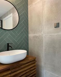 a bathroom sink sitting on top of a wooden counter next to a wall mounted mirror