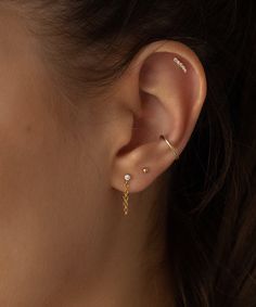 a woman's ear is shown with two different piercings