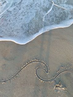 a wave is drawn in the sand at the beach