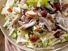 a salad with meat, grapes and lettuce on a plate