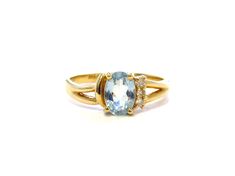 A beautiful vintage ring set in 14k yellow gold with a lovely sky blue colored oval-cut topaz and diamond accents.  The ring features 3 accent diamonds on one side, and then the ring has a split shank at the top. The blue topaz measures 7mm x 5mm.  There are 3-1.5mm diamonds set in the sides of the ring. Blue Topaz is the December birthstone. This piece is a vintage ring and shows just light even wear in the way of minor surface marks, but no serious scratches, scuffs, or damage. This ring is a Oval Topaz Ring With Diamond Accents In 14k Gold, Oval Topaz Ring With Diamond Accents For Anniversary, Oval Yellow Gold Topaz Ring With Diamond Accents, Heirloom Oval Topaz Ring With Diamond Accents, Blue Topaz Ring Gold, Gold Topaz Ring, Topas Ring, Sky Blue Topaz Ring, Gold Skies