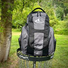 a backpack sitting on top of a metal stand next to a tree