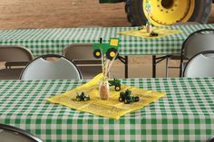 a table topped with green and white checkered tables cloths covered in small tractors