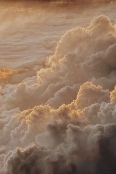 an airplane flying in the sky above some clouds