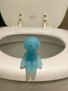 a blue toy sitting on top of a toilet seat