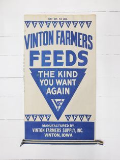 a blue and white sign hanging on the side of a building that says, union farmers feeds the kind you want again