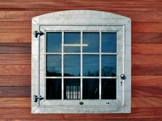 a window on the side of a wooden wall