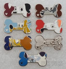 six different colored dog bone shaped magnets on a white surface with black, red, blue, yellow and green designs