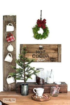 a wooden sign that says hot cocoa bar next to a christmas tree and mugs