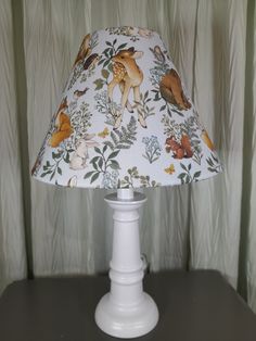 a lamp that is sitting on top of a table in front of a curtained wall