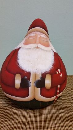 a santa clause statue sitting on top of a brown and white checkered table cloth