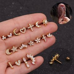 six pairs of ear studs with stars, moon and heart shapes on them in gold tone