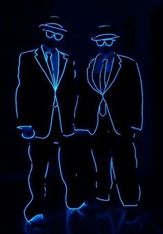 two men in suits and hats are lit up with neon lights