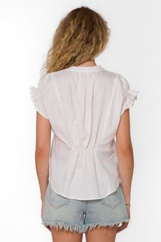 Exquisitely crafted, the Avery Top showcases a flattering V-neck pop-over style complemented by short ruffle sleeves, adding a touch of femininity. The cinched back ensures a comfortable and effortlessly chic fit. Material: 100% Linen Machine wash cold or hand wash Color: Optic White Model is 5'9" and wearing a size S Imported Relaxed Fit V-neck Top With Ruffles, Casual V-neck Top With Smocked Back, Short Sleeve Ruched Blouse, Short Sleeve Ruched Blouse For Day Out, Summer Ruched Short Sleeve Tops, Ruched Short Sleeve Blouse For Day Out, Summer Short Sleeve Ruched Blouse, Elegant Short Sleeve Blouse With Smocked Back, Casual Blouse With Flutter Sleeves And Smocked Back