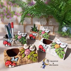 four small planters with flowers and birds painted on them are sitting on a table