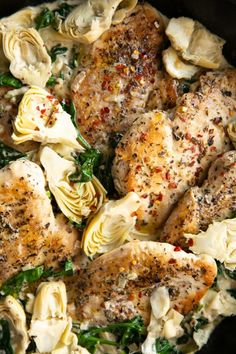 chicken, artichokes and spinach in a skillet with seasoning