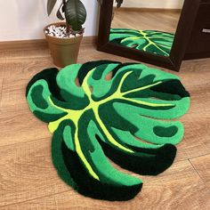 a green and yellow rug sitting on top of a wooden floor next to a mirror