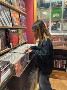 a woman looking at records in a record store