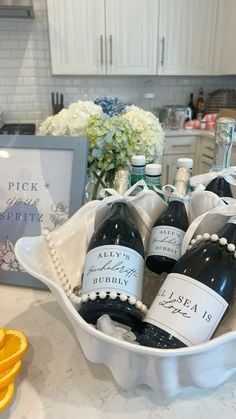 a bowl filled with bottles of wine on top of a counter next to an orange slice