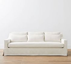 a white couch sitting on top of a hard wood floor