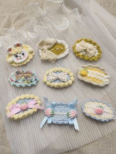 there are many small crocheted items on the table together, including brooches