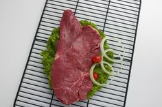 a piece of meat sitting on top of lettuce