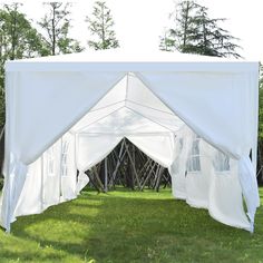 a large white tent sitting on top of a lush green field