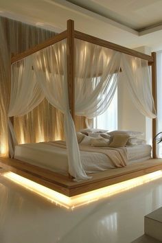 a bed with white sheets and curtains in a room