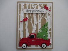 a red truck with a christmas tree on the back is sitting in front of a white wall