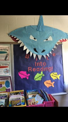 a bulletin board with a shark on it and other books in front of the door