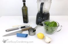 a blender filled with green vegetables next to other kitchen tools and utensils