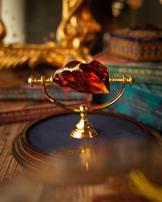 a golden object on top of a wooden table next to some books and other items