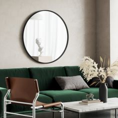 a living room with a green couch and round mirror