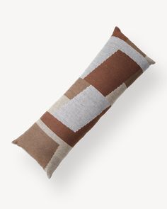 a brown and white striped pillow on a white background