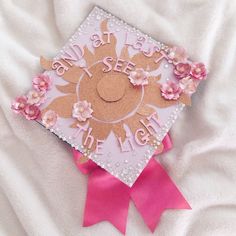 a pink and white graduation cap with flowers on it