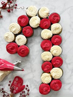 a letter made out of cupcakes and icing on top of a table