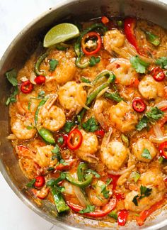 a pan filled with shrimp, peppers and cilantro