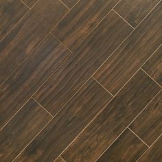 a close up view of a wooden floor with dark wood grains on the tile