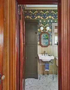 an open door leading to a bathroom with a sink and mirror on the wall above it