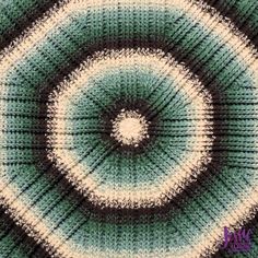 an image of a knitted rug with a circular design in green and white colors