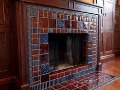 a fireplace with red and blue tiles on it