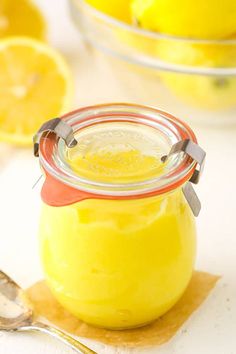 a glass jar filled with lemon custard on top of a table