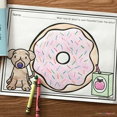 a doughnut with sprinkles on it next to two crayons