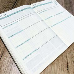 an open planner sitting on top of a wooden table