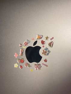 an apple sticker on the side of a laptop with hearts and stars all over it